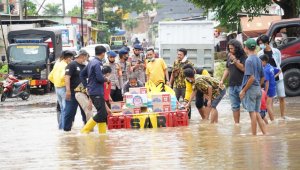 Kader AMPG menggunakan perahu untuk mengantarkan sembako dan makan siap saji ke rumah warga di Biringkanaya. (Ist)
