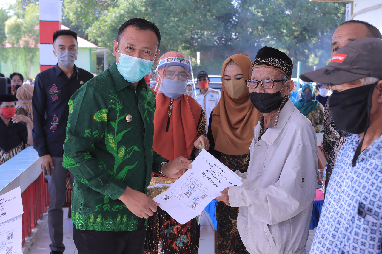 Bupati Takalar Syamsari Kitta menyerahkan secara simbolik BLT kepada warga di desa Timbuseng, kecamatan Polongbangkeng Utara, Kamis 25 Juni 2020. (Ist)