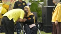 Politisi Partai Golkar Rahman Pina mencium tangan salah satu tim pemenangannya yang datang menghadiri konsolidasi di Max One Hotel meski menggunakan kursi roda. (Ist)