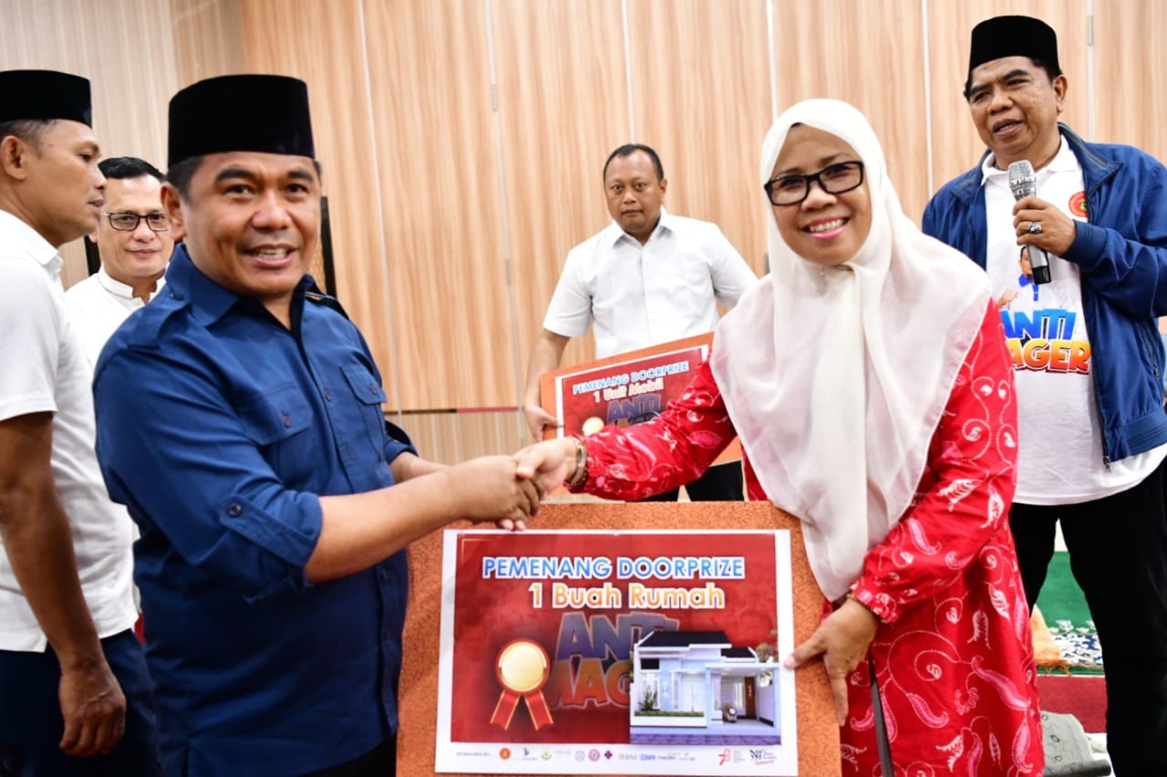 Ketua Harian IKA Unhas Rahman Pina menyerahkan hadiah rumah secara simbolis kepada pemenang undian jalan anti mager IKA Unhas bekerja sama dengan Pemprov Sulsel di gedung AAS Building, Jumat 18 Agustus 2023. (Ist)
