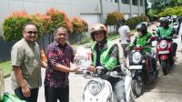 Ketua Haeian IKA Unhas Rahman Pina menyalurkan beras kepada salah satu driver ojek online di Makassar, Kamis 5 Maret 2026. (Ist)
