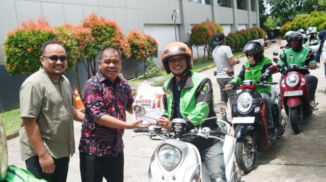 Ketua Haeian IKA Unhas Rahman Pina menyalurkan beras kepada salah satu driver ojek online di Makassar, Kamis 5 Maret 2026. (Ist)