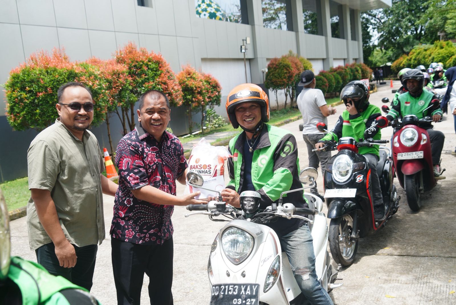 Ketua Haeian IKA Unhas Rahman Pina menyalurkan beras kepada salah satu driver ojek online di Makassar, Kamis 5 Maret 2026. (Ist)