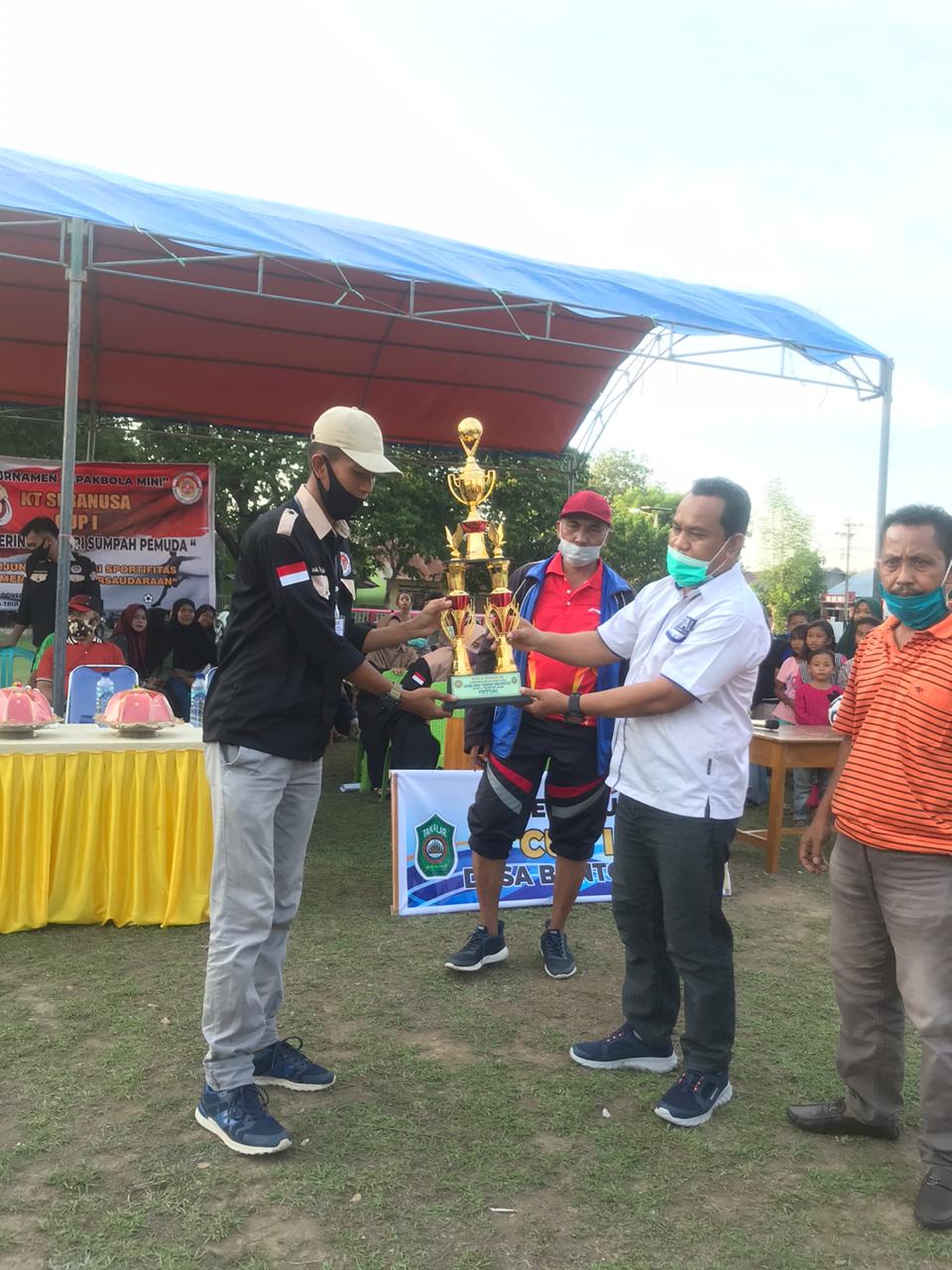 Ketua AFK Takalar Abdullah Hasan menyerahkan piala bergilir kepada panitia turnamen sepak bola mini di Desa Bontoloe, Rabu 28 Oktober 2020. (Ist)
