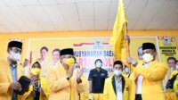 Usman Marham memegang pataka usai terpilih memimpin DPD II Golkar Pinrang, Minggu 25 April 2021. (Ist)